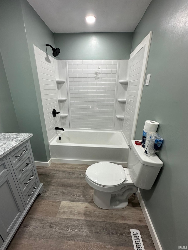 full bathroom featuring toilet, vanity, wood-type flooring, and bathtub / shower combination