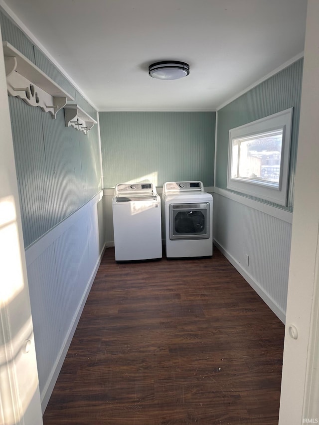 washroom featuring wood walls, dark hardwood / wood-style floors, and washing machine and clothes dryer