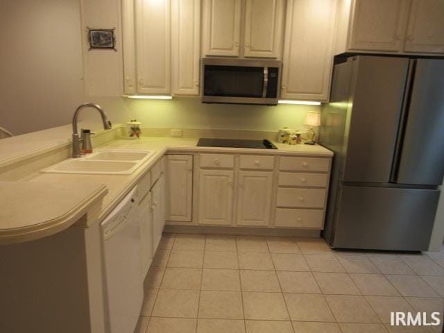 kitchen featuring light tile patterned floors, sink, kitchen peninsula, and black appliances