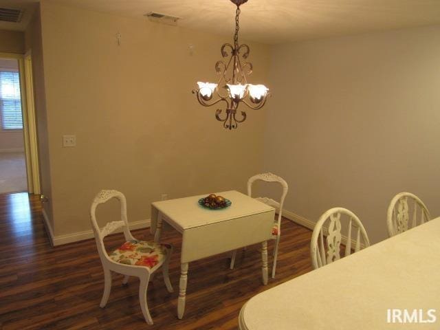 dining room featuring dark hardwood / wood-style flooring and a notable chandelier