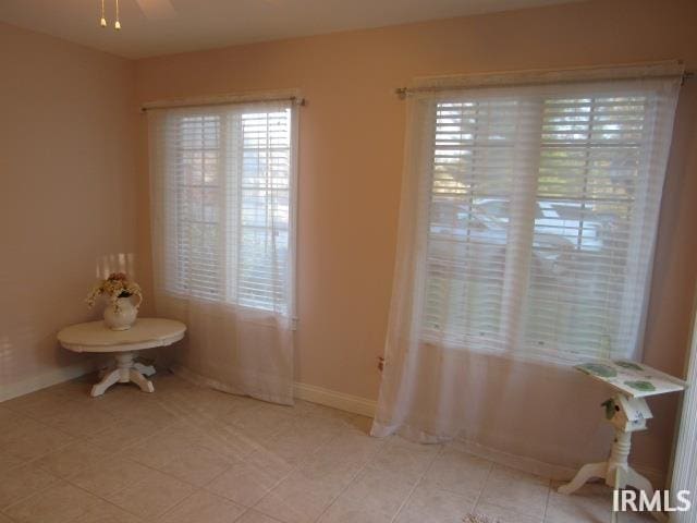 bathroom with ceiling fan and tile patterned flooring