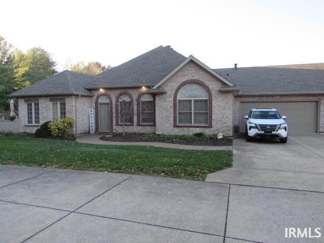 ranch-style house featuring a front lawn and a garage