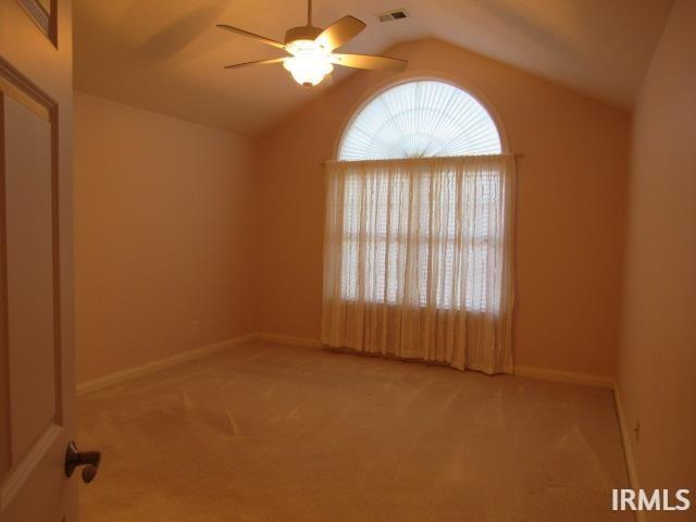 spare room with carpet floors, ceiling fan, and vaulted ceiling