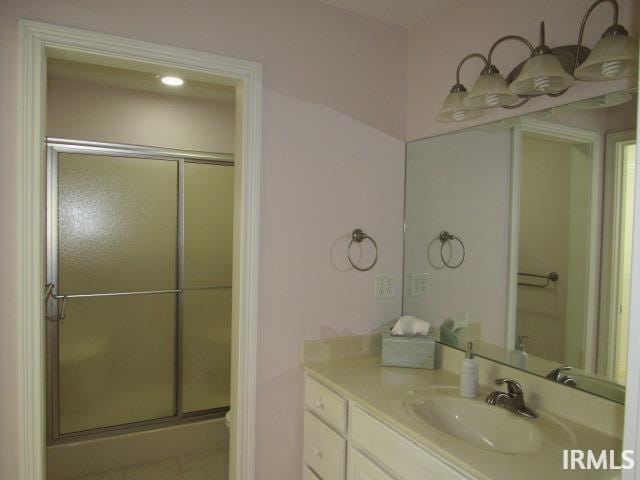 bathroom with a shower with door and vanity