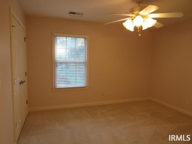 empty room with light carpet and ceiling fan