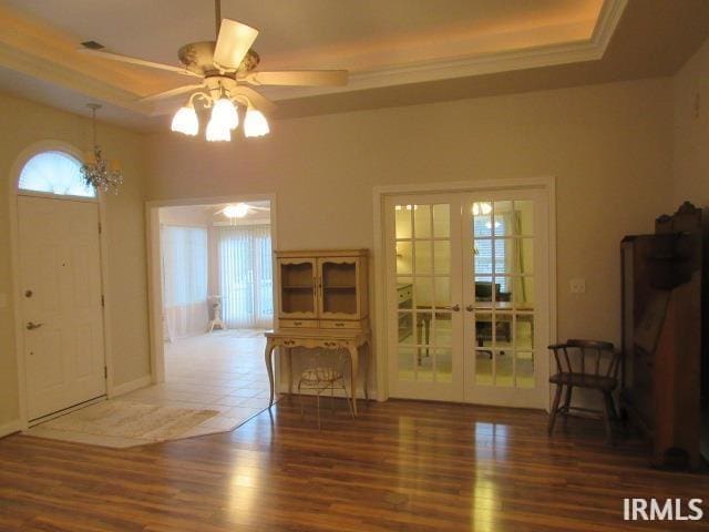 foyer with french doors, dark hardwood / wood-style floors, plenty of natural light, and a tray ceiling