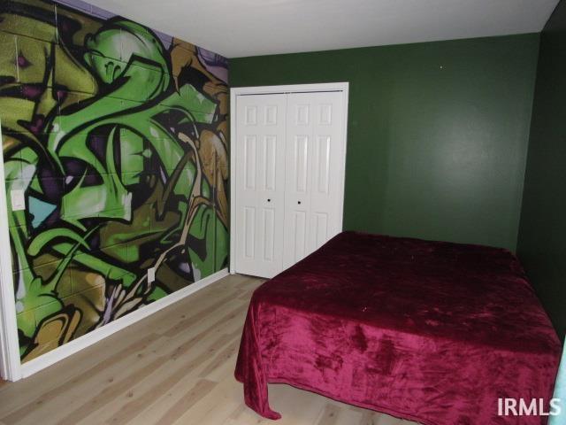 bedroom featuring wood-type flooring and a closet