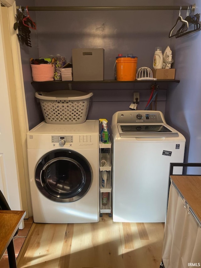 washroom with light hardwood / wood-style flooring and washing machine and clothes dryer