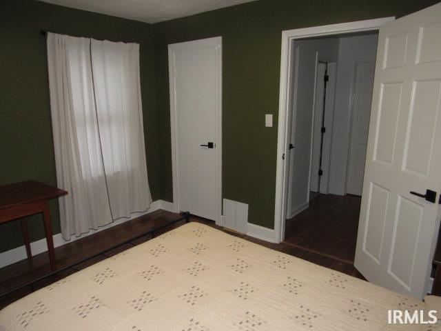 unfurnished bedroom featuring dark hardwood / wood-style flooring