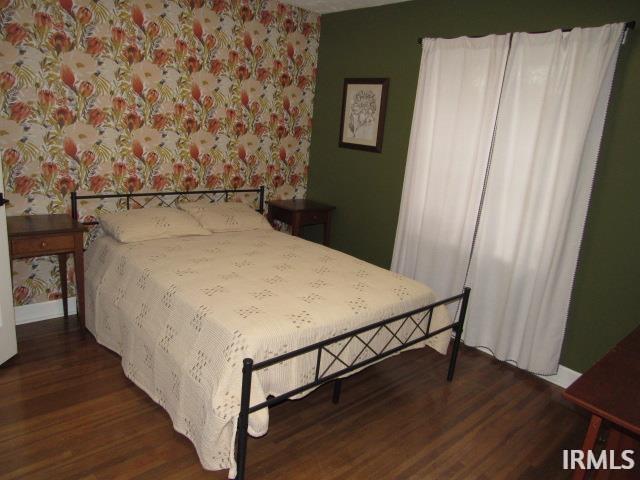 bedroom with dark hardwood / wood-style flooring