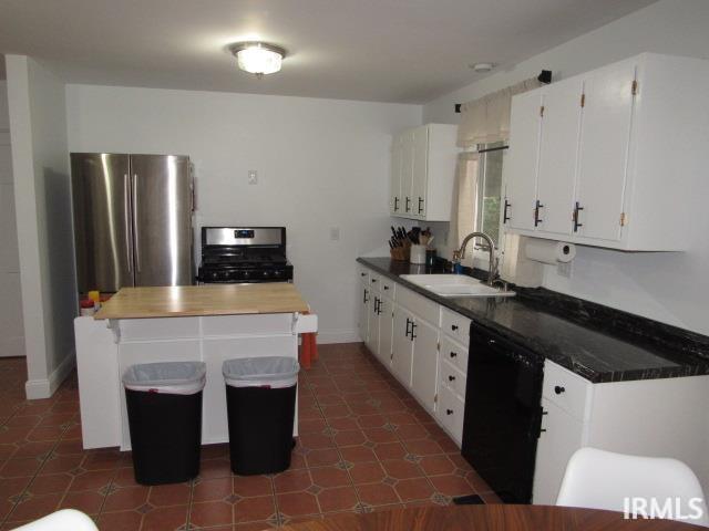 kitchen with appliances with stainless steel finishes, a center island, white cabinetry, sink, and a kitchen breakfast bar