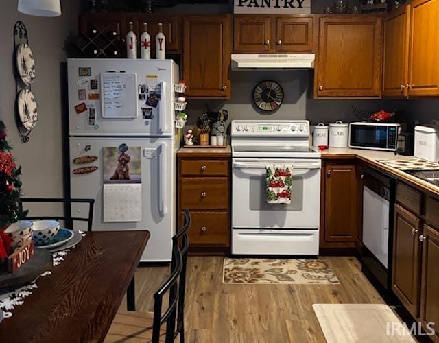 kitchen with light hardwood / wood-style floors and white appliances