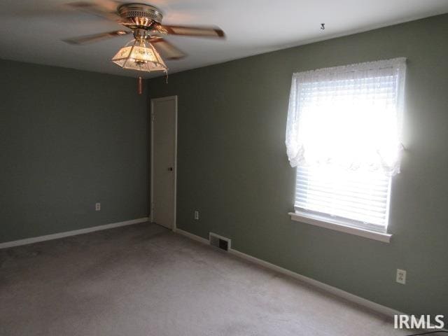 carpeted empty room with ceiling fan and a healthy amount of sunlight