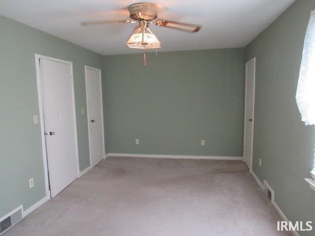 carpeted spare room with ceiling fan