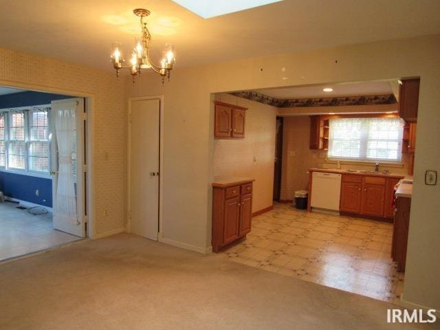 kitchen with a chandelier, pendant lighting, dishwasher, and sink