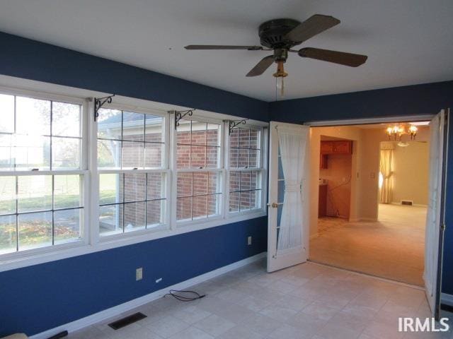 unfurnished bedroom with ceiling fan with notable chandelier