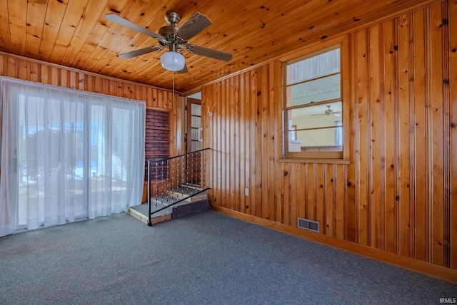 unfurnished room featuring ceiling fan, carpet flooring, a wealth of natural light, and wooden ceiling