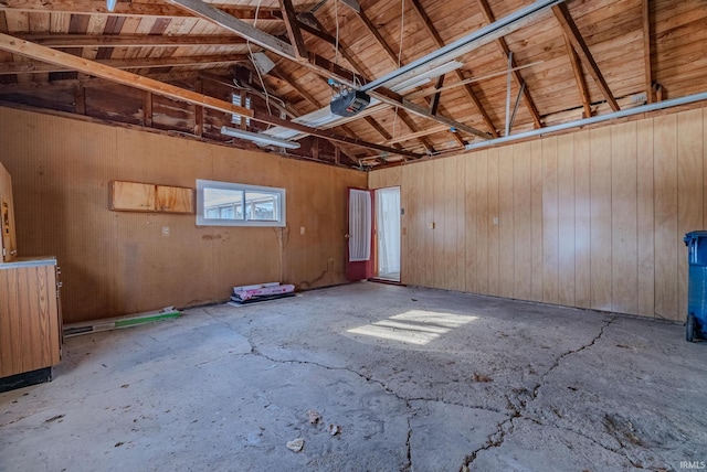 garage with a garage door opener and wood walls