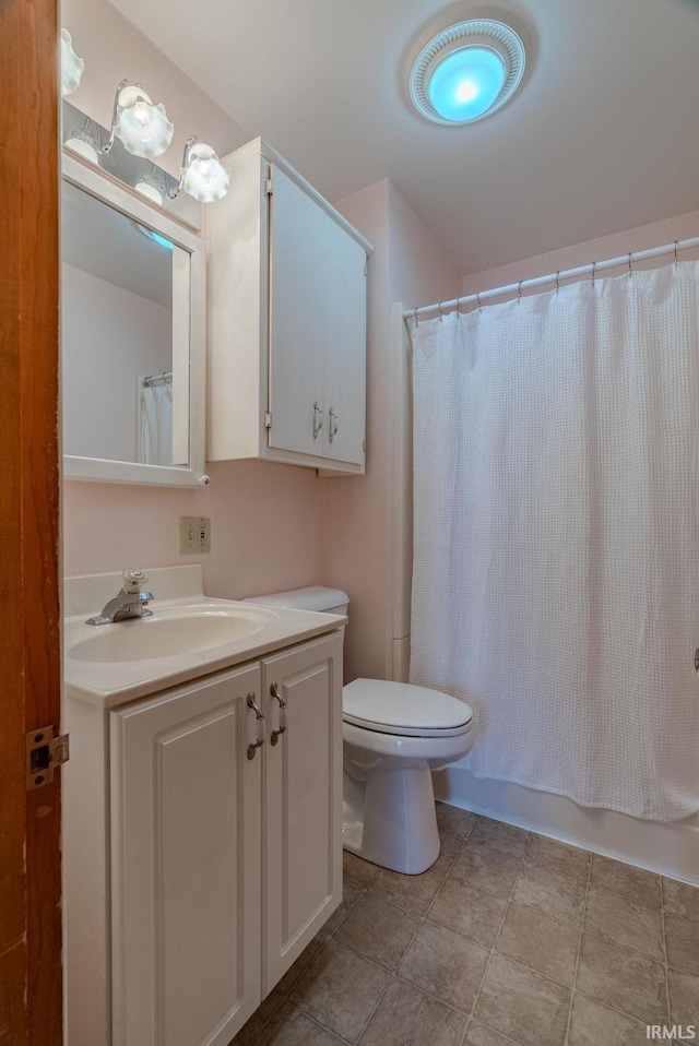 full bathroom featuring toilet, shower / bath combination with curtain, and vanity