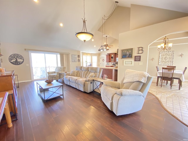 living room featuring high vaulted ceiling, dark wood-type flooring, and an inviting chandelier