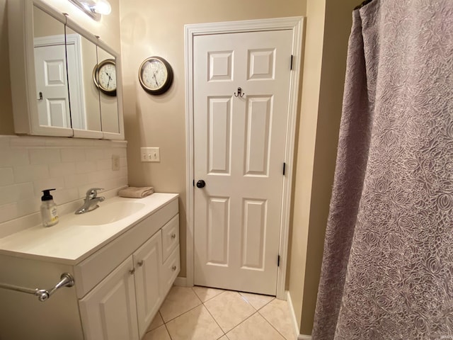 bathroom featuring tile patterned flooring, vanity, and tasteful backsplash