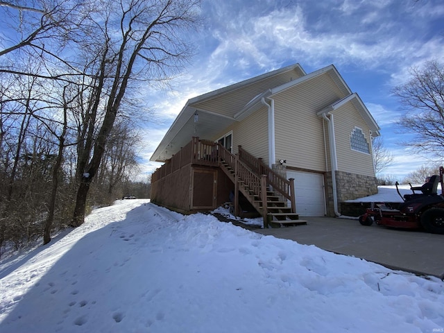 view of snowy exterior featuring a garage