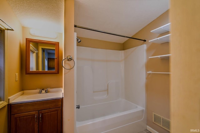 bathroom with shower / bathtub combination, a textured ceiling, and vanity