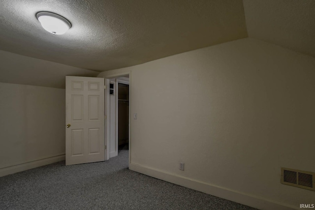 bonus room with a textured ceiling and vaulted ceiling