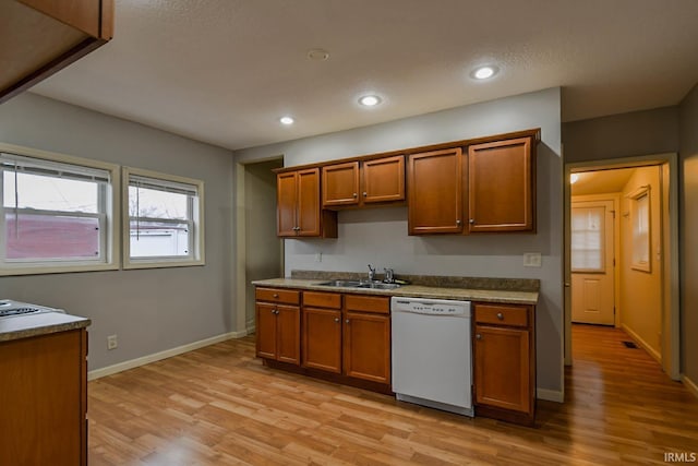 kitchen featuring dishwasher, sink, and light hardwood / wood-style flooring