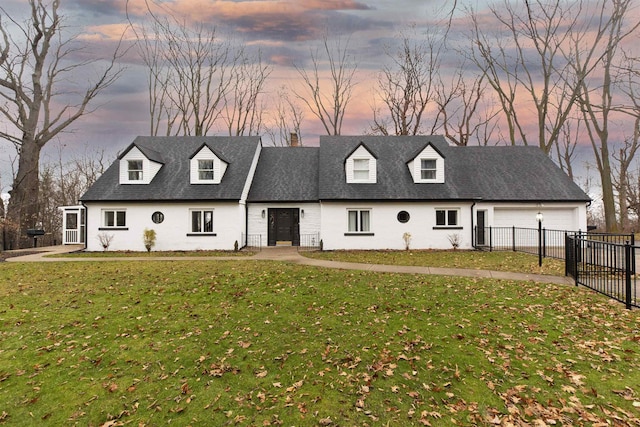 cape cod home with a garage and a lawn