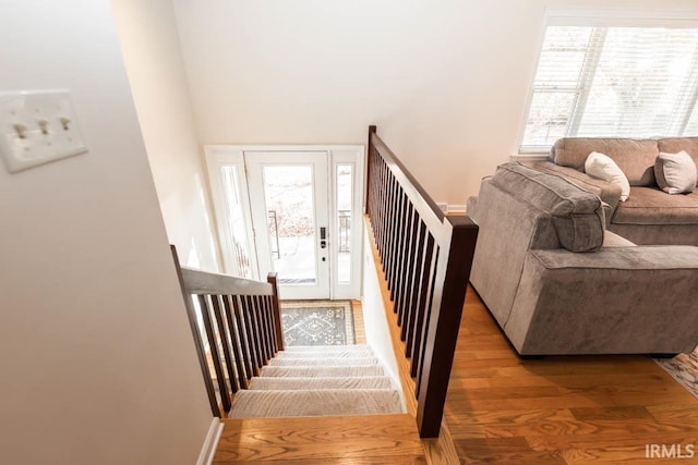 staircase with a wealth of natural light and hardwood / wood-style floors