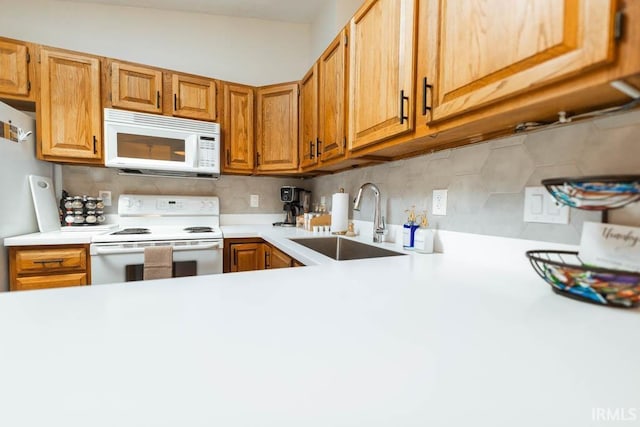 kitchen with sink, backsplash, and white appliances