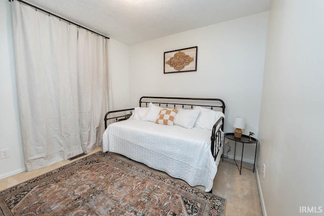 bedroom with light carpet and a textured ceiling