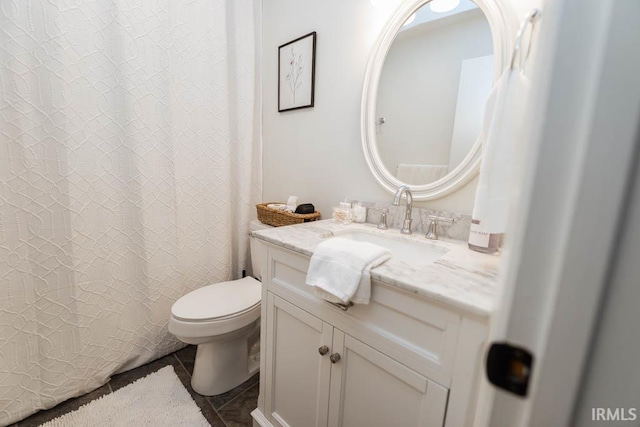 bathroom featuring tile patterned floors, vanity, and toilet