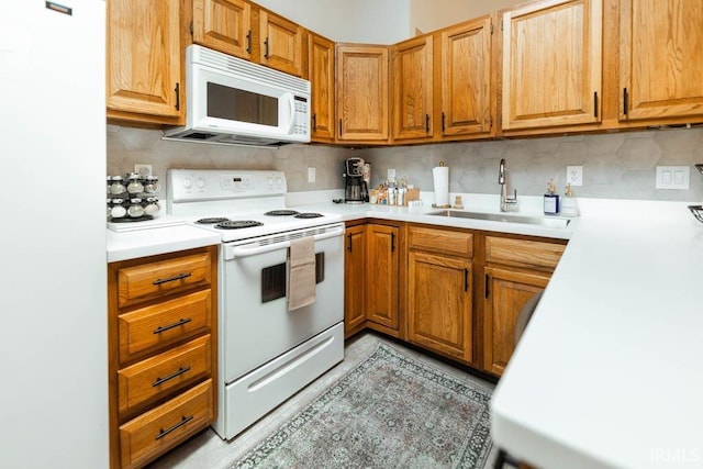 kitchen featuring sink, white appliances, and backsplash