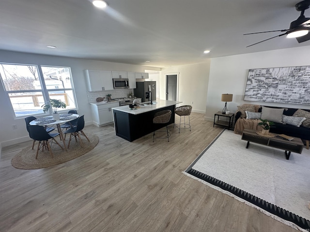 living room with light hardwood / wood-style floors and ceiling fan