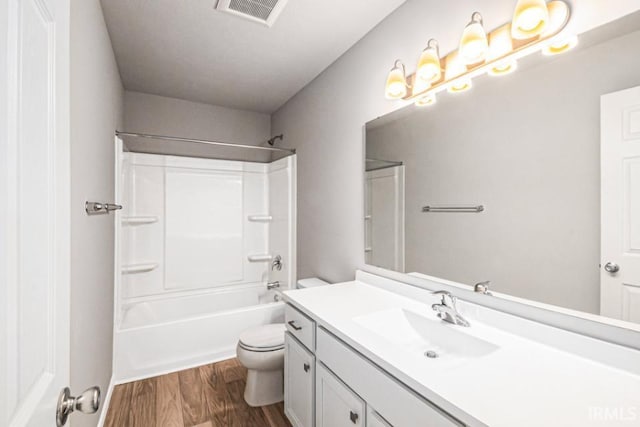 full bath featuring bathing tub / shower combination, visible vents, toilet, vanity, and wood finished floors