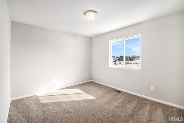 unfurnished room featuring carpet, visible vents, and baseboards