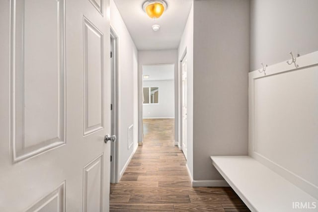 mudroom with wood finished floors, visible vents, and baseboards