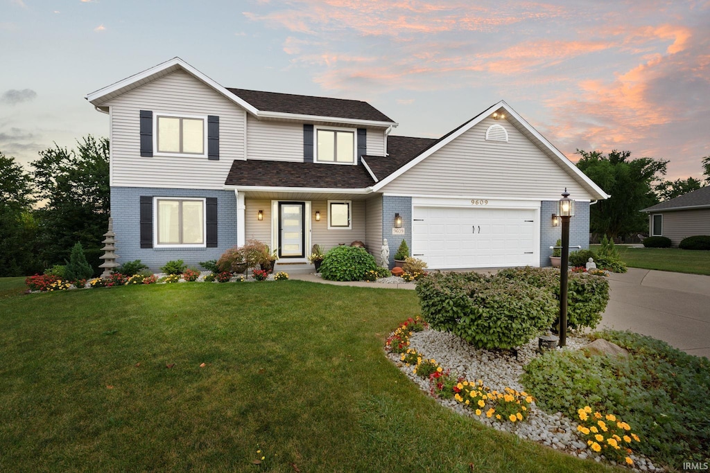 view of property featuring a garage and a lawn