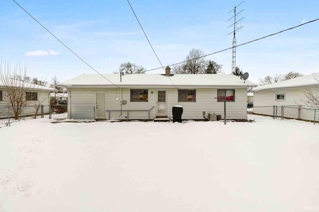 snow covered back of property featuring central air condition unit