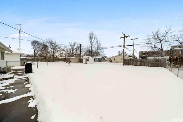 snowy yard featuring central AC