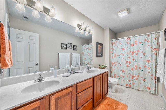 bathroom featuring toilet, vanity, tile patterned floors, and a textured ceiling