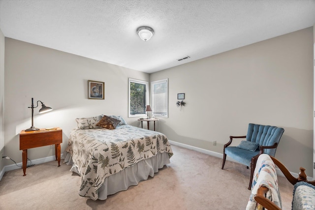 bedroom with light carpet and a textured ceiling