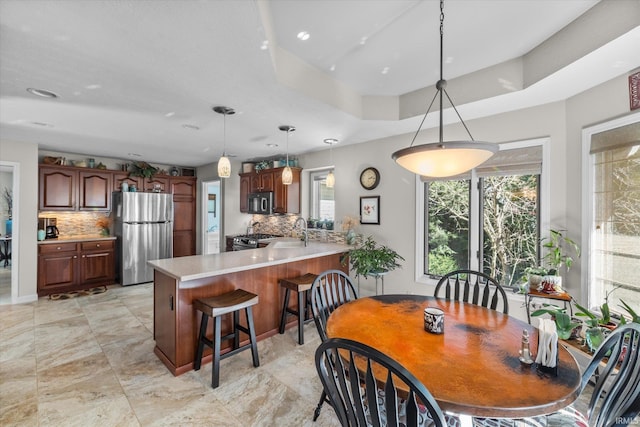 dining area with a tray ceiling and sink