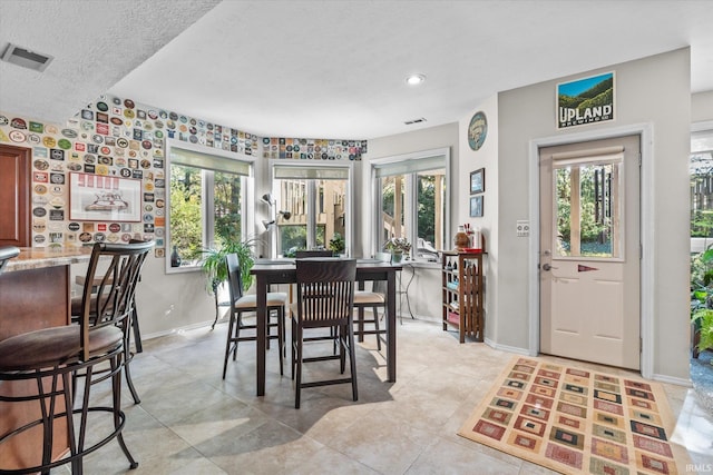 dining area featuring a textured ceiling and light tile patterned flooring