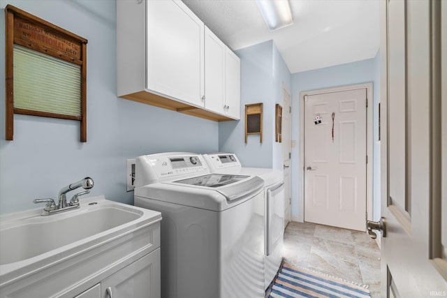 clothes washing area with cabinets, separate washer and dryer, and sink