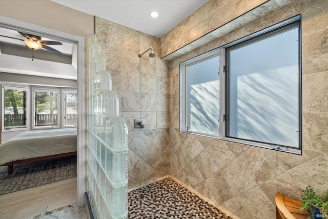 bathroom featuring ceiling fan and a tile shower