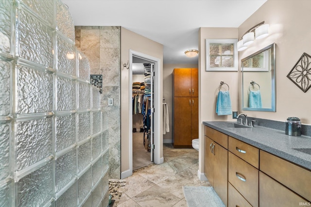 bathroom featuring walk in shower, vanity, and toilet