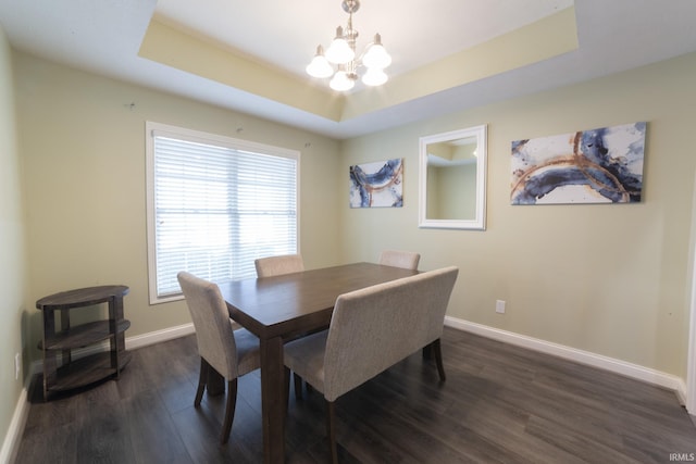 dining room featuring an inviting chandelier, dark hardwood / wood-style flooring, and a raised ceiling